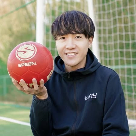 リフティングのプロshu先生がspeenballレッドを持ってこちらを笑顔で見ている画像